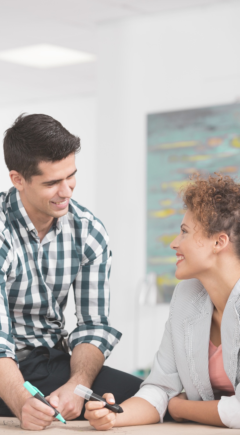 Handsome businessman flirting with his female workmate in office